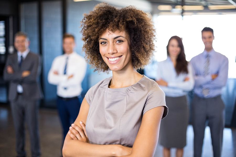 Successful businesswoman smiling at camera while his colleagues